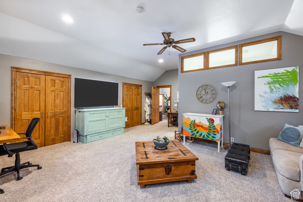 Living room featuring lofted ceiling, carpet floors, and ceiling fan