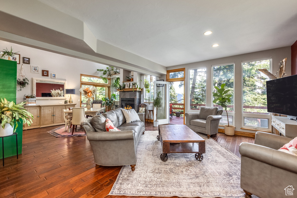 Living area featuring a tiled fireplace, dark wood finished floors, and recessed lighting