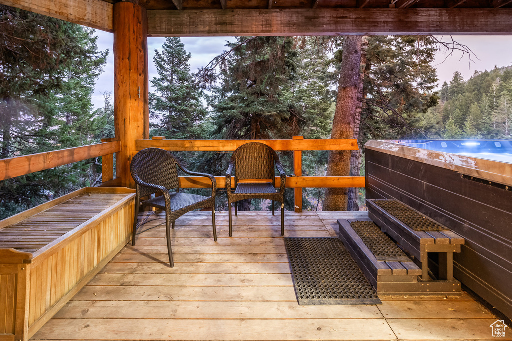 Deck at dusk featuring a hot tub