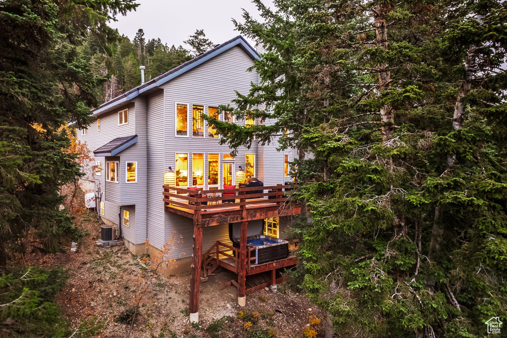 Rear view of property with central AC and a wooden deck