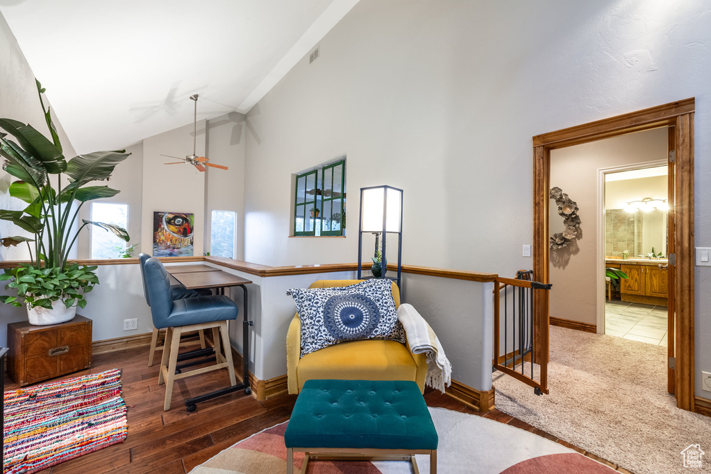 Sitting room featuring ceiling fan, high vaulted ceiling, and wood-type flooring