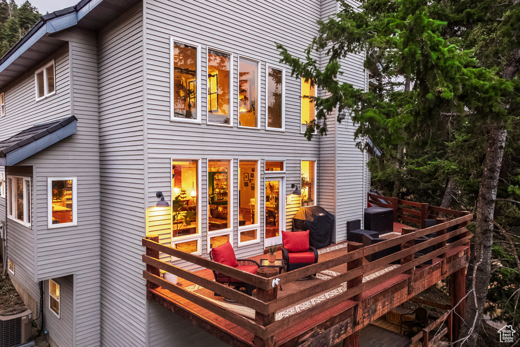 Rear view of property featuring central AC and a wooden deck