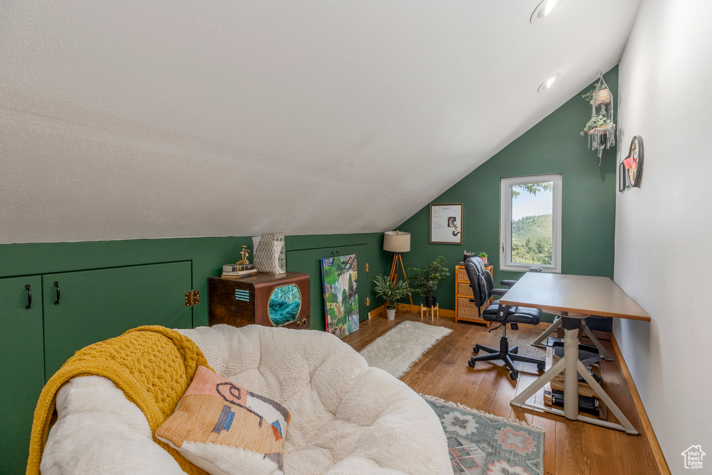 Home office with wood finished floors and lofted ceiling