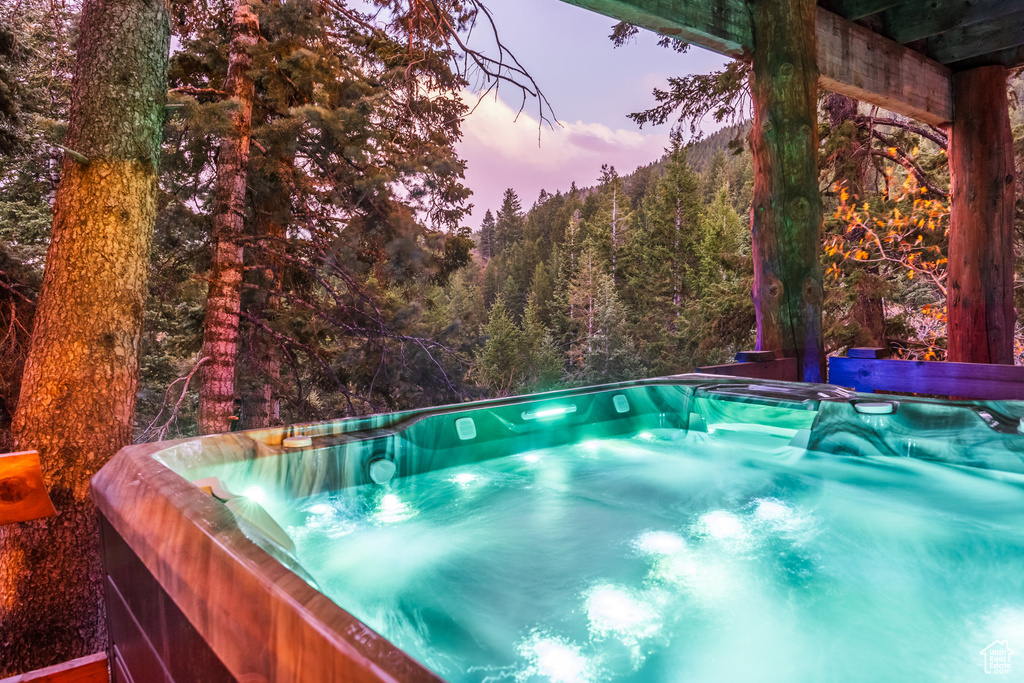 Pool at dusk featuring a hot tub