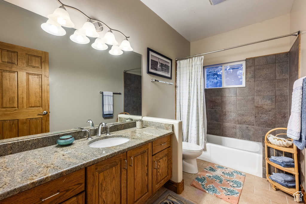 Full bathroom with vanity, shower / tub combo, toilet, and tile patterned flooring