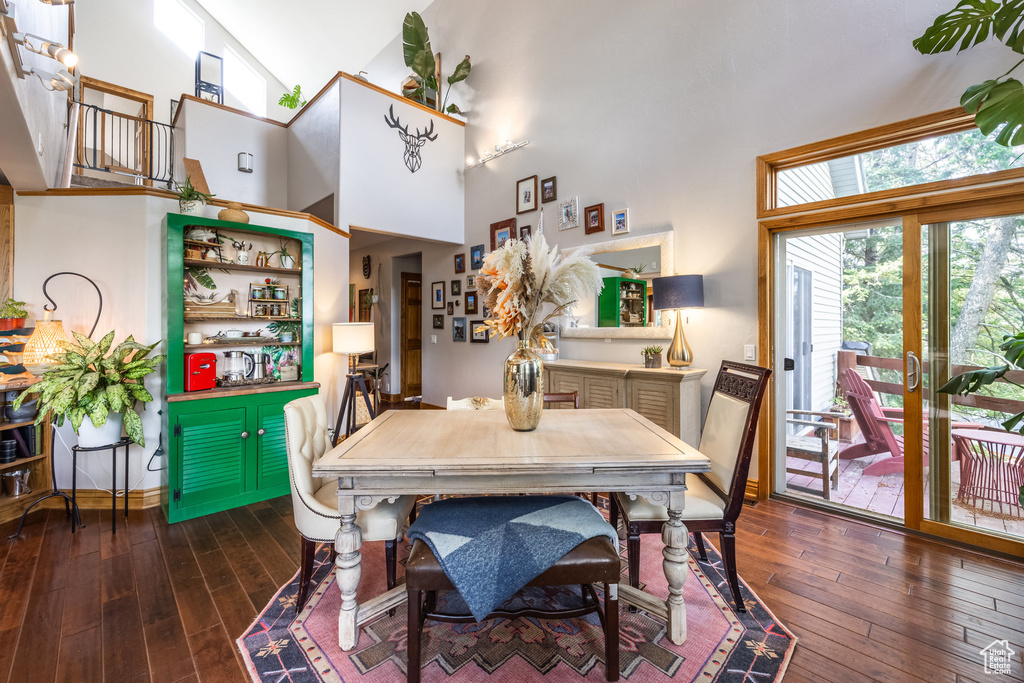 Dining space with a high ceiling and hardwood / wood-style flooring