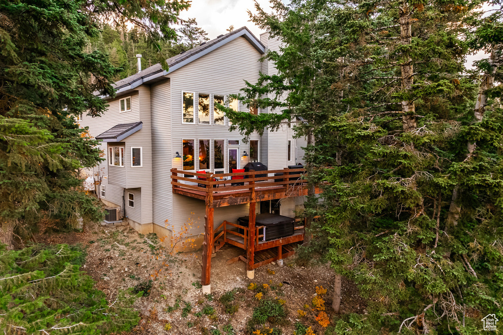Back of property featuring a deck and central AC unit