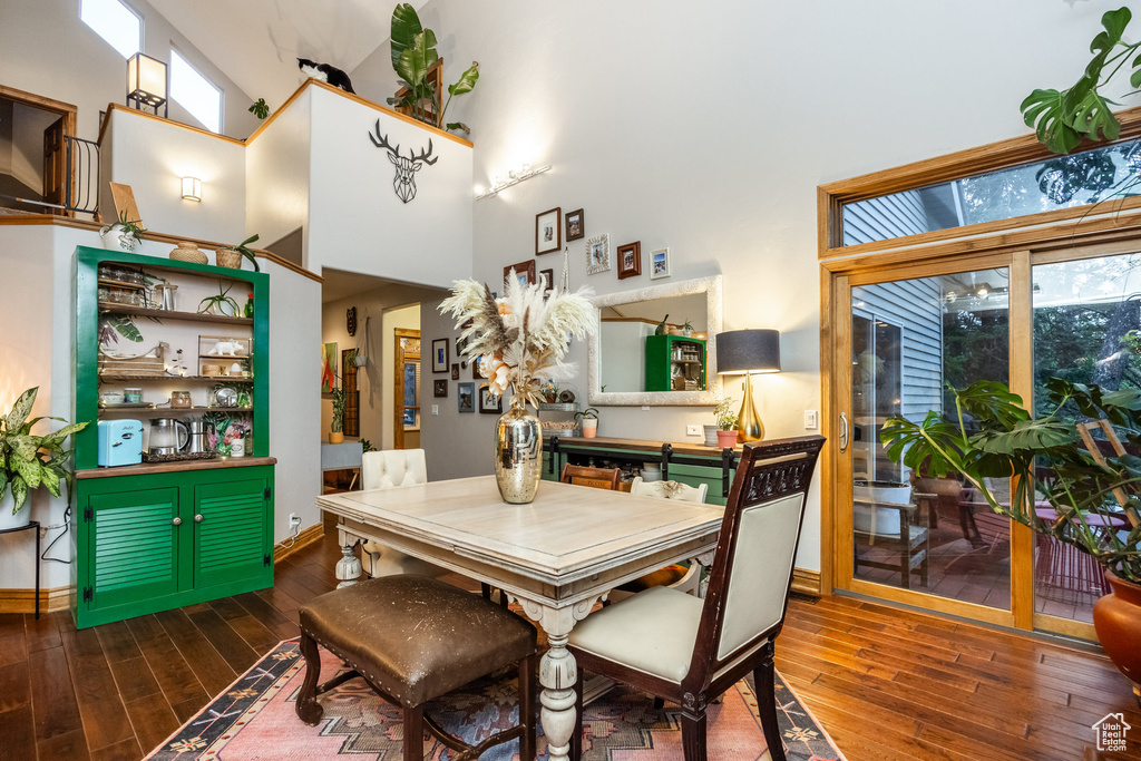 Dining area featuring dark wood-type flooring and a high ceiling
