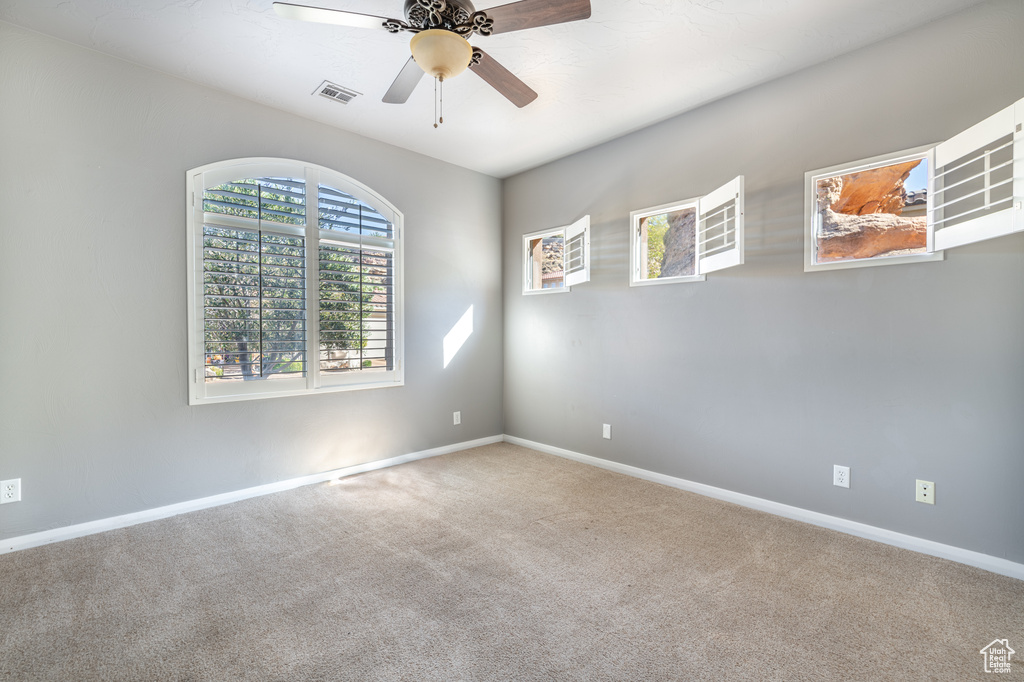 Carpeted empty room with ceiling fan