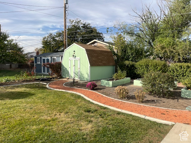 View of outdoor structure featuring a lawn