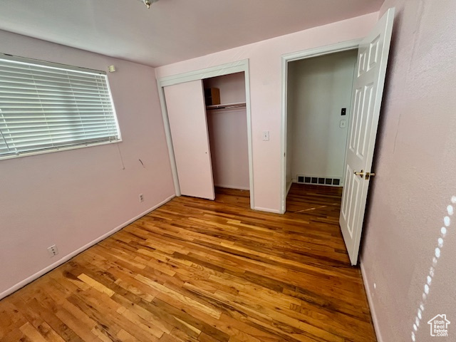 Unfurnished bedroom with light hardwood / wood-style floors and a closet