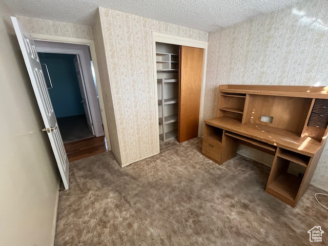 Office space featuring a textured ceiling and carpet flooring