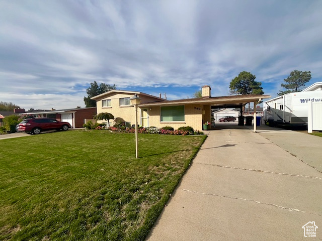 View of front facade with a carport and a front yard