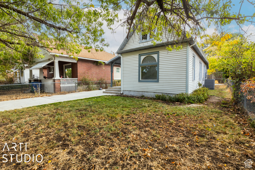 View of front of house with a front lawn and central AC unit