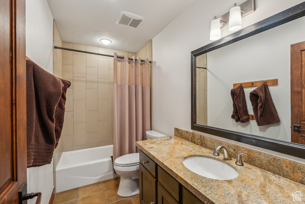 Full bathroom with shower / bath combination with curtain, toilet, tile patterned flooring, and vanity