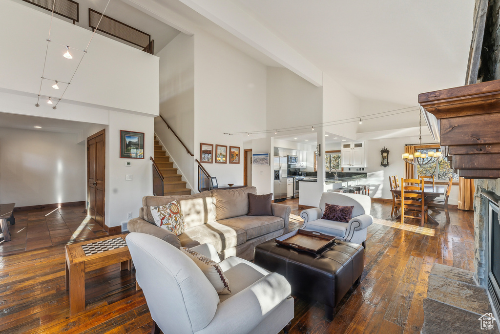 Living room featuring high vaulted ceiling, a fireplace, and dark hardwood / wood-style flooring