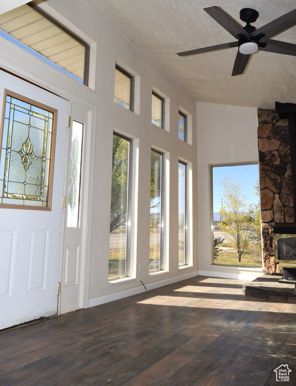 Interior space with ceiling fan, a textured ceiling, and dark hardwood / wood-style flooring