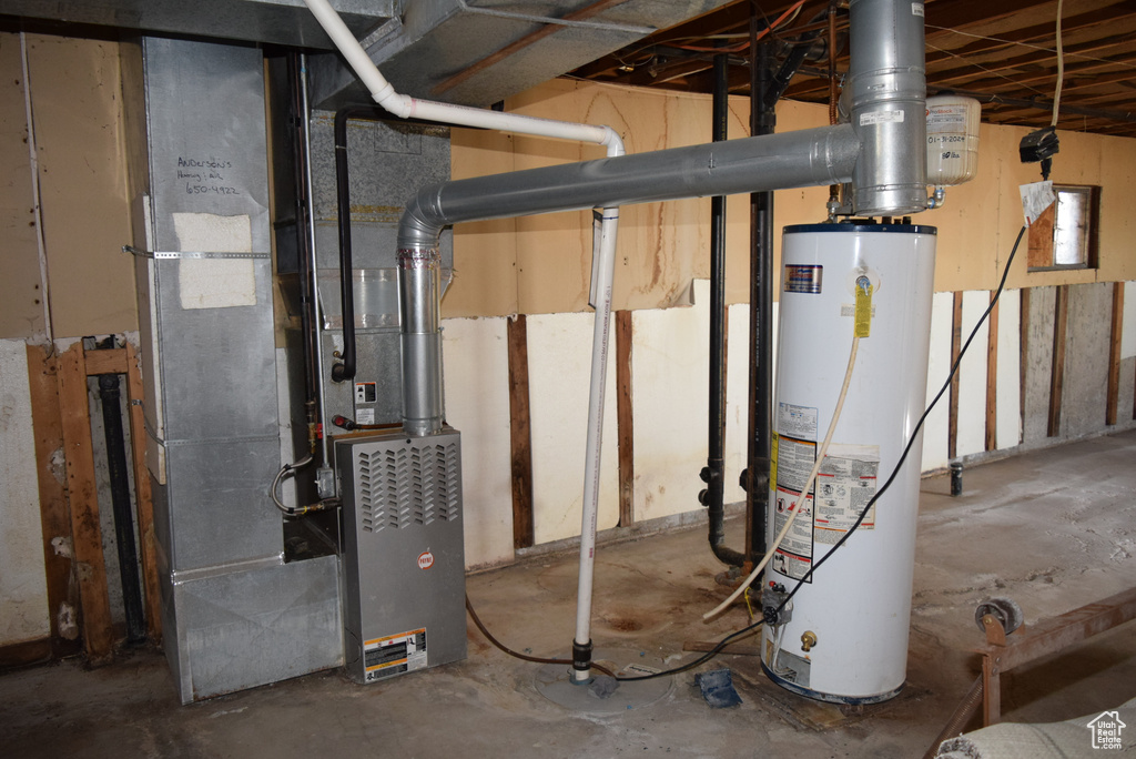 Utility room featuring water heater and heating unit