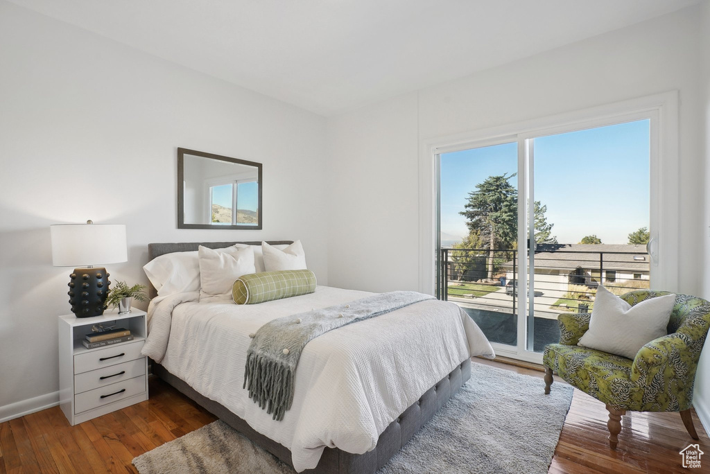 Bedroom with access to exterior and dark hardwood / wood-style flooring