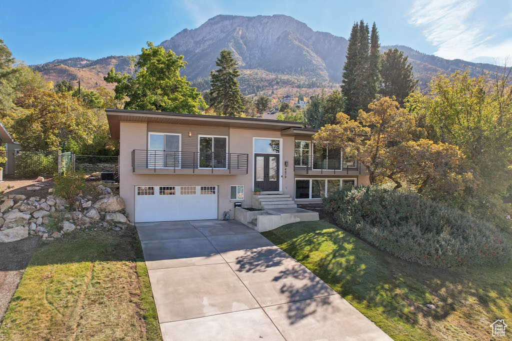 View of front of property with a mountain view, a balcony, and a garage