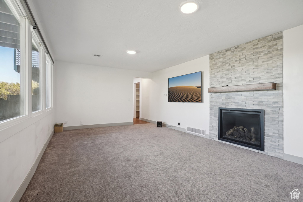 Unfurnished living room with carpet floors and a fireplace