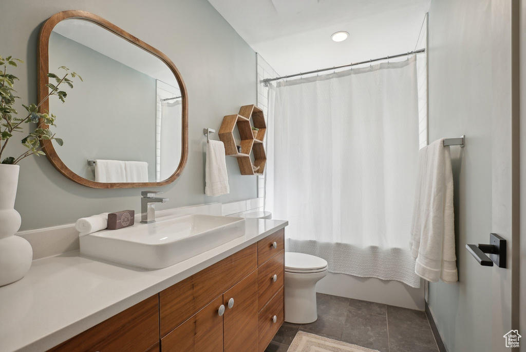 Full bathroom featuring vanity, toilet, shower / bathtub combination with curtain, and tile patterned flooring