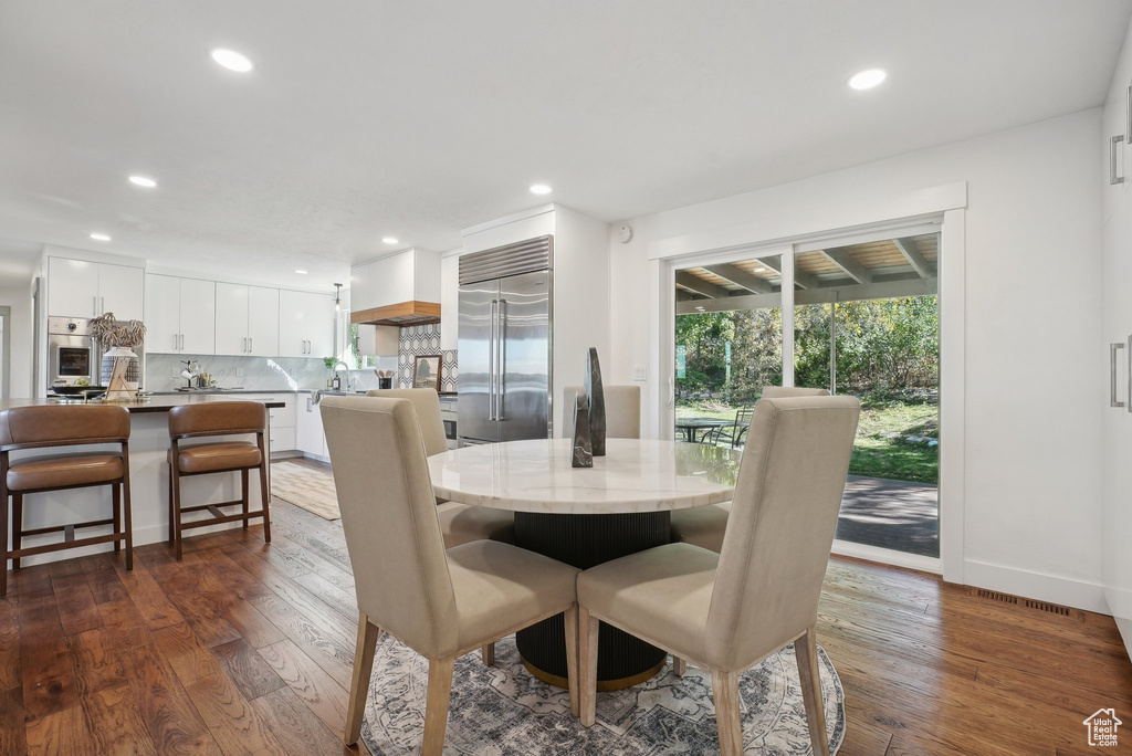 Dining space with dark hardwood / wood-style flooring