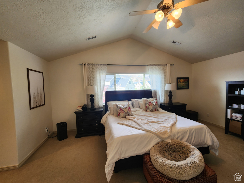 Bedroom featuring light carpet, a textured ceiling, ceiling fan, and lofted ceiling