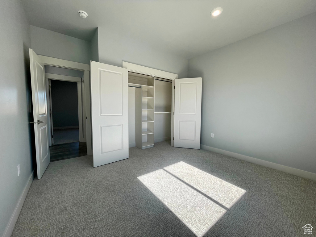 Unfurnished bedroom with a closet and carpet