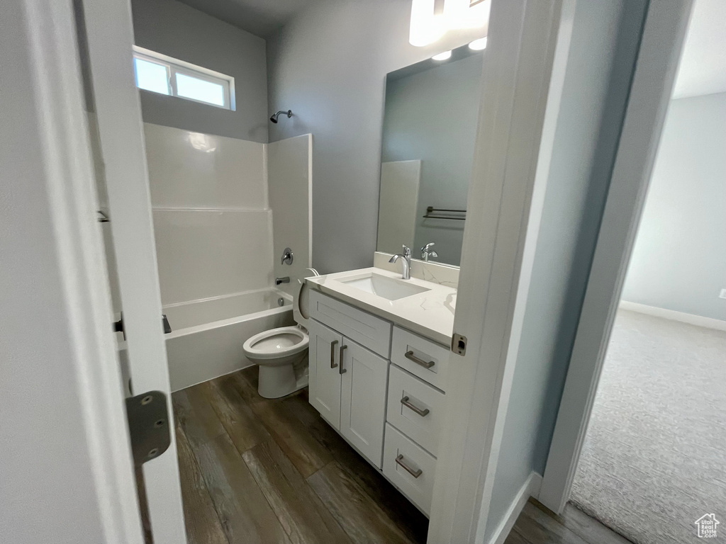 Full bathroom featuring toilet, shower / washtub combination, hardwood / wood-style flooring, and vanity