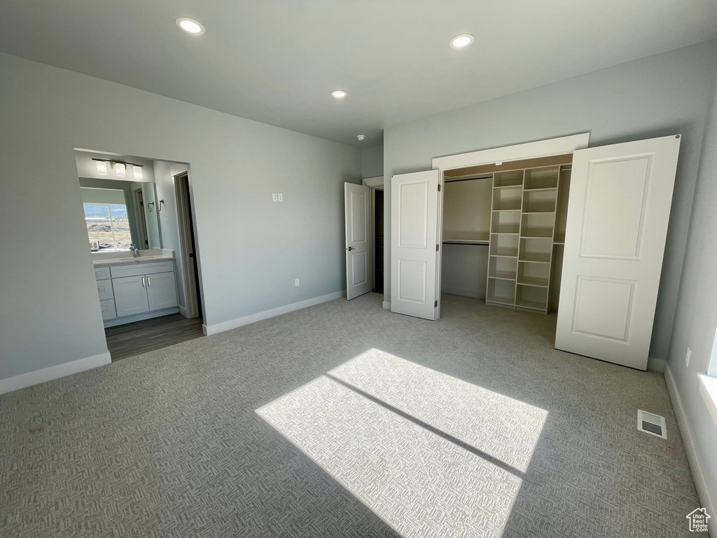 Unfurnished bedroom featuring a closet, carpet, and a walk in closet