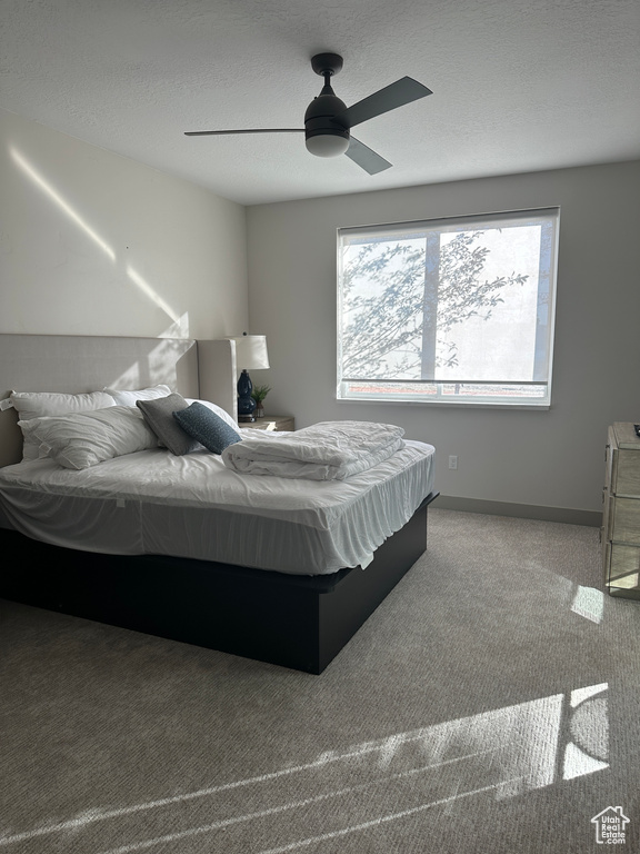 Bedroom featuring ceiling fan, a textured ceiling, and carpet floors