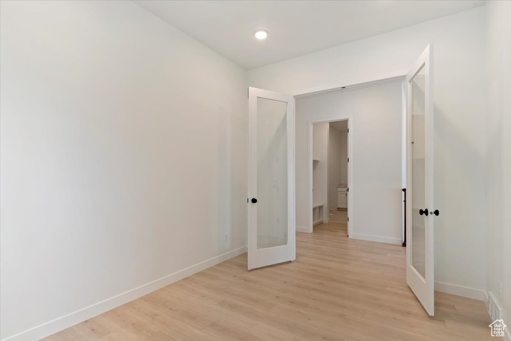 Empty room featuring light hardwood / wood-style flooring and french doors