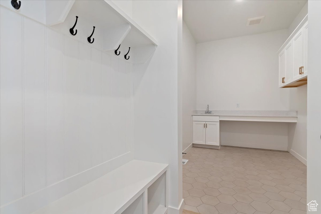 Mudroom with light tile patterned flooring and sink