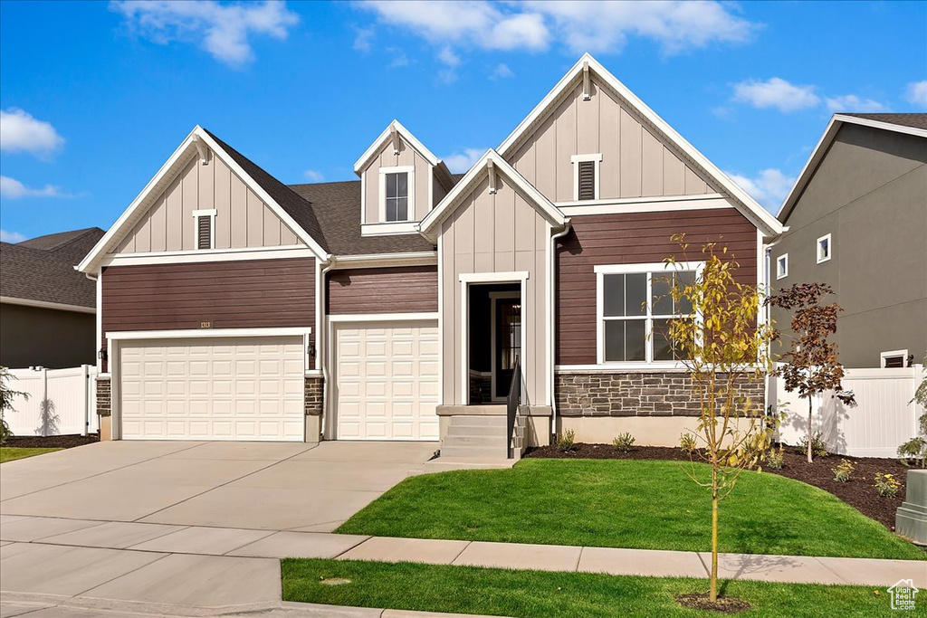 Craftsman-style house with a garage and a front lawn