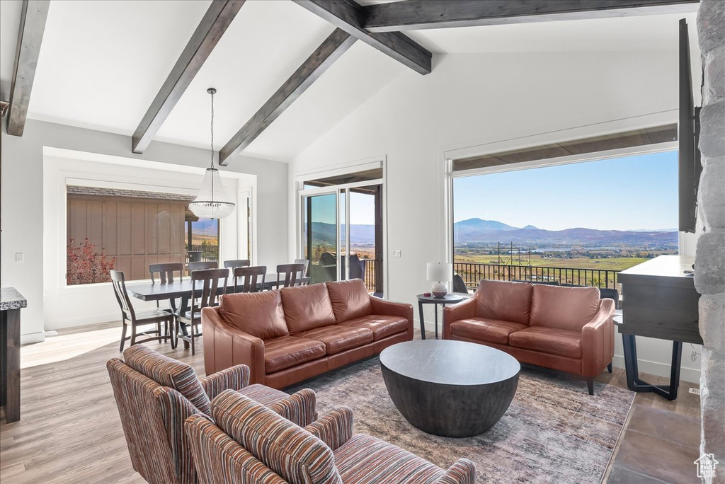 Living room featuring a mountain view, lofted ceiling with beams, and hardwood / wood-style floors