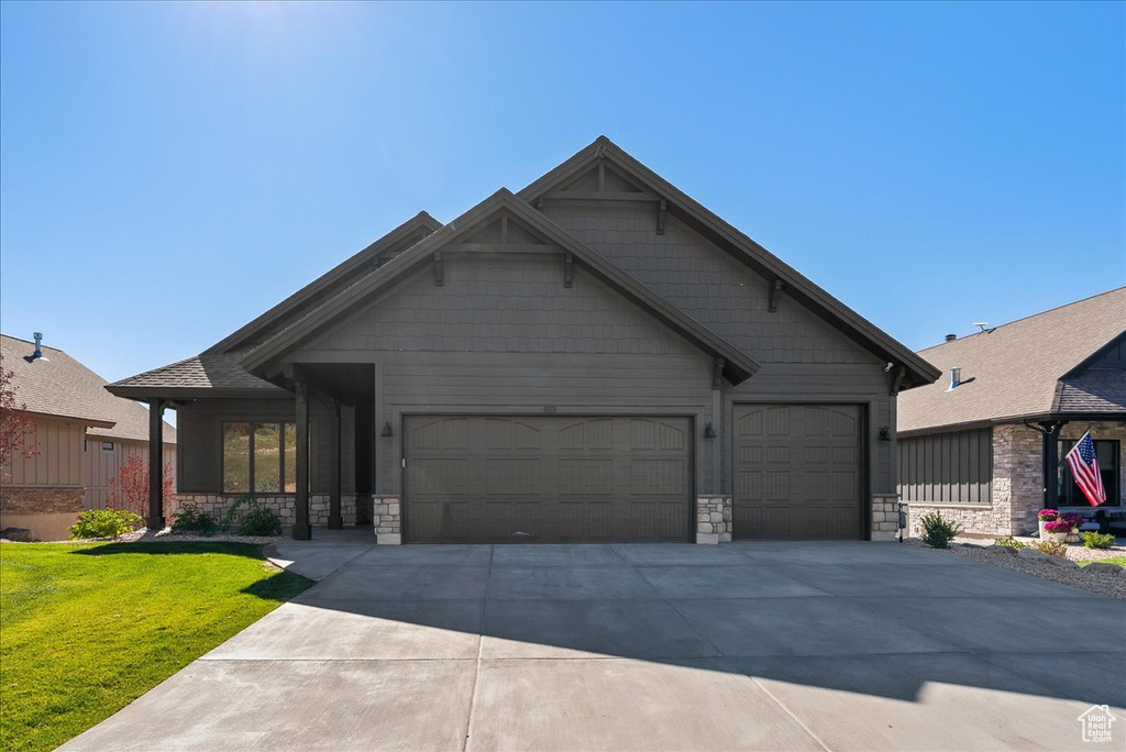 Craftsman house featuring a front yard and a garage