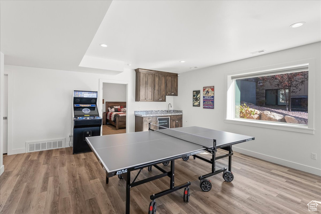 Playroom featuring light hardwood / wood-style flooring, sink, and beverage cooler