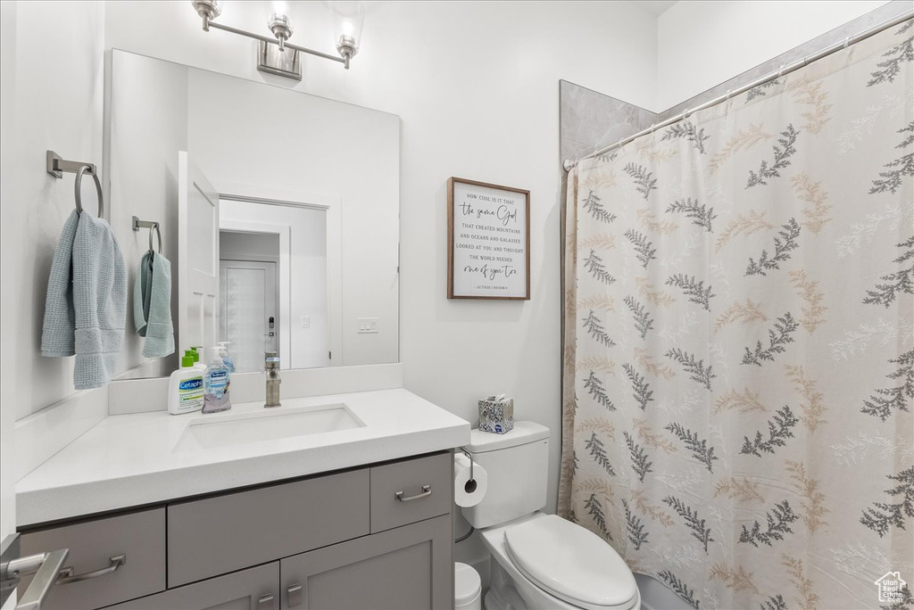 Bathroom with vanity, toilet, and a shower with shower curtain