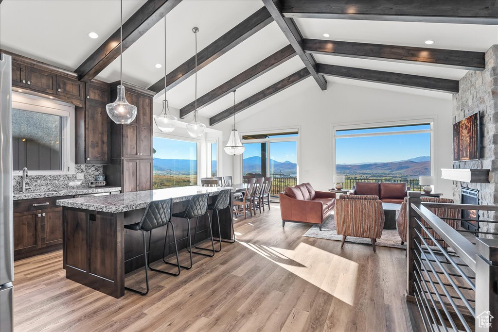 Kitchen with light hardwood / wood-style floors, a mountain view, light stone counters, and hanging light fixtures