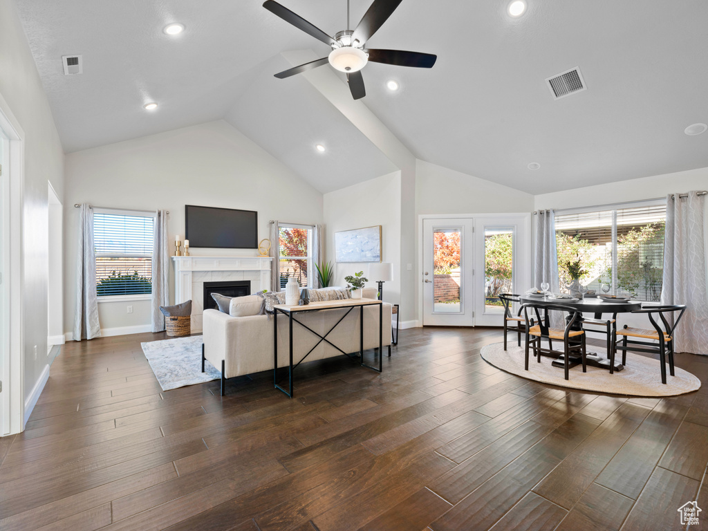 Living room with ceiling fan, high vaulted ceiling, and dark hardwood / wood-style flooring