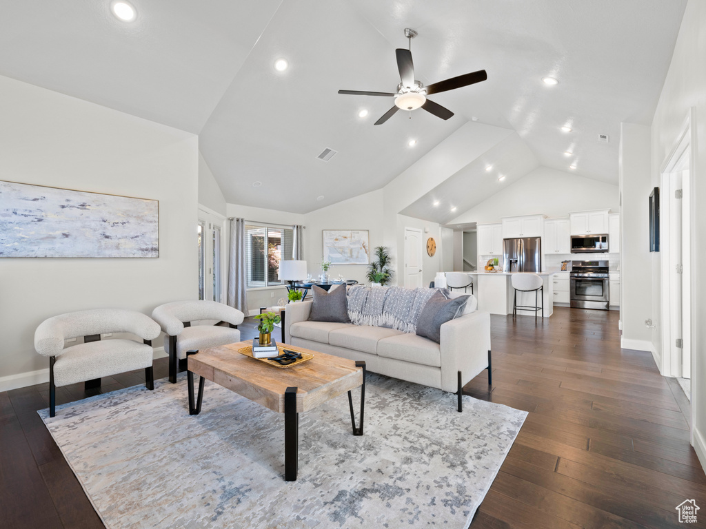 Living room featuring high vaulted ceiling, dark wood-type flooring, and ceiling fan