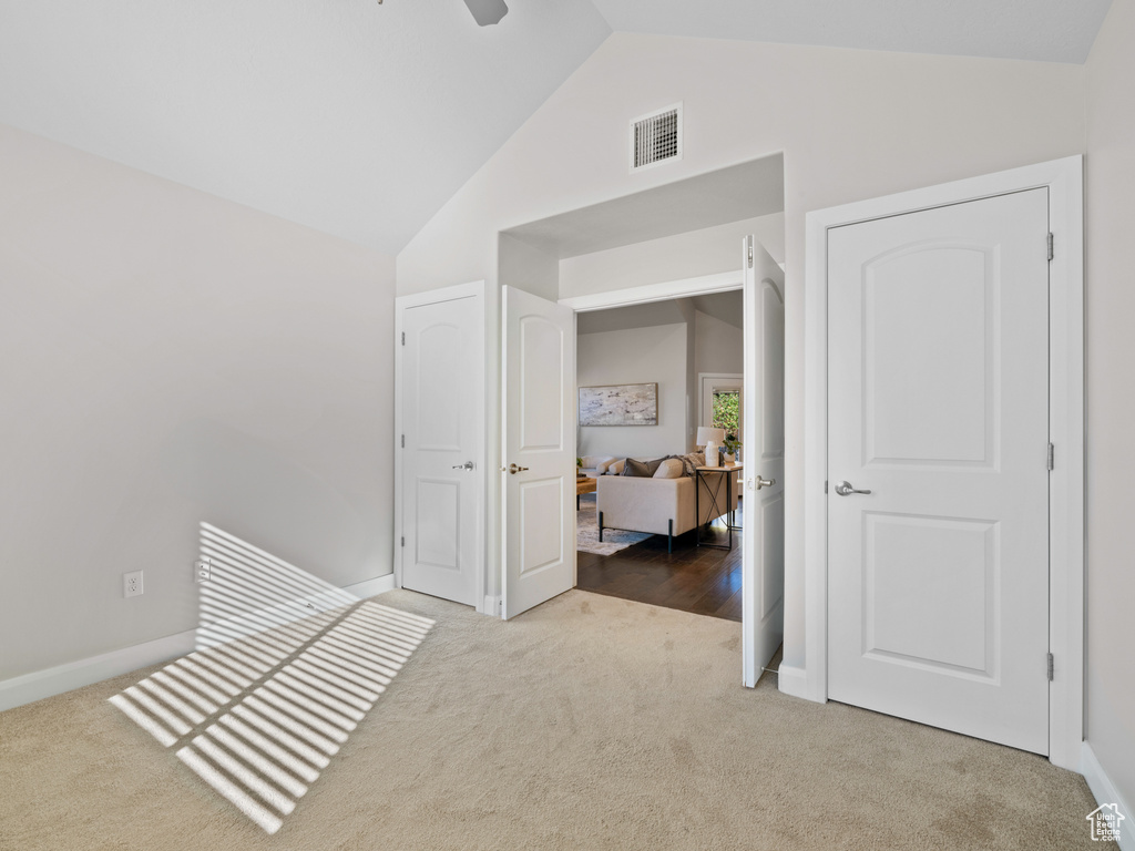 Hallway with lofted ceiling and carpet flooring