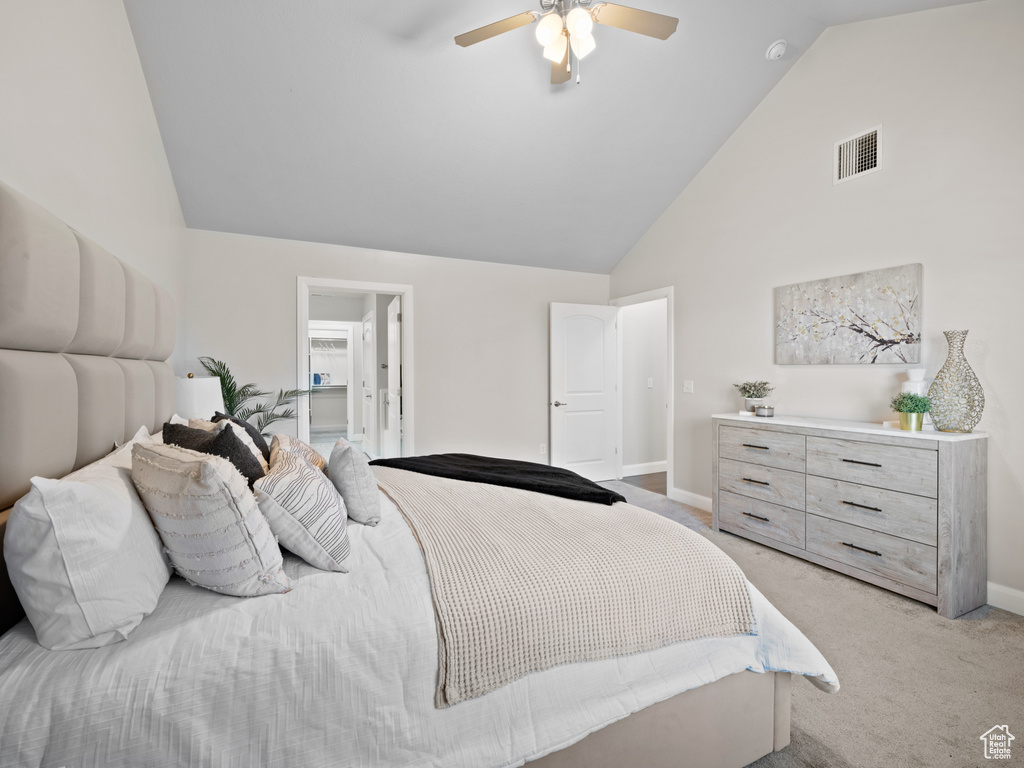 Carpeted bedroom with high vaulted ceiling and ceiling fan