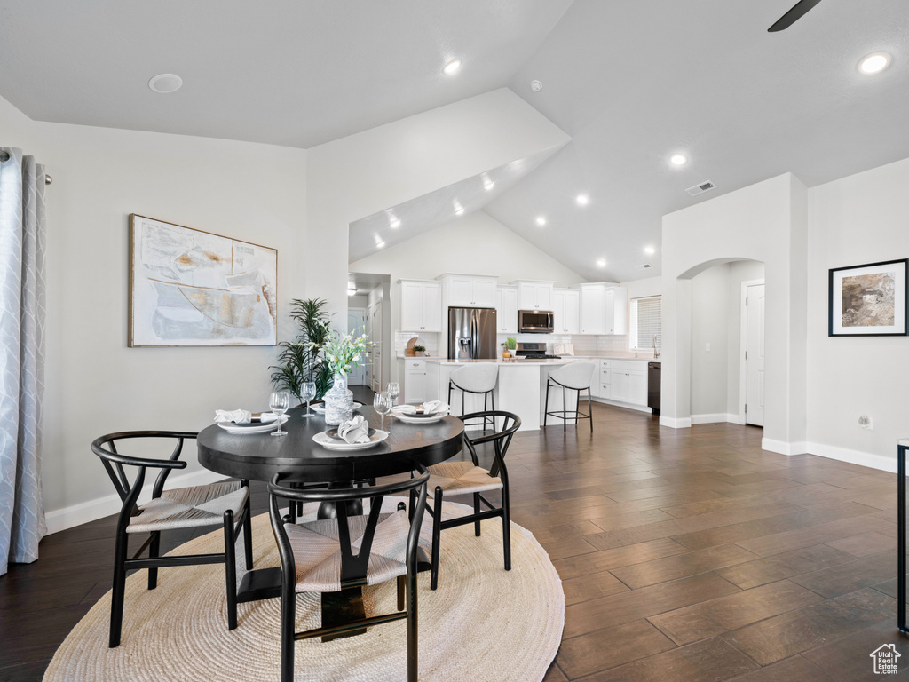 Dining space with lofted ceiling and dark wood-type flooring