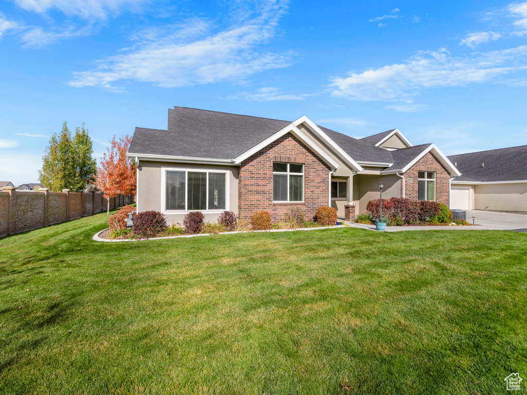 View of front of property featuring a front yard and a garage