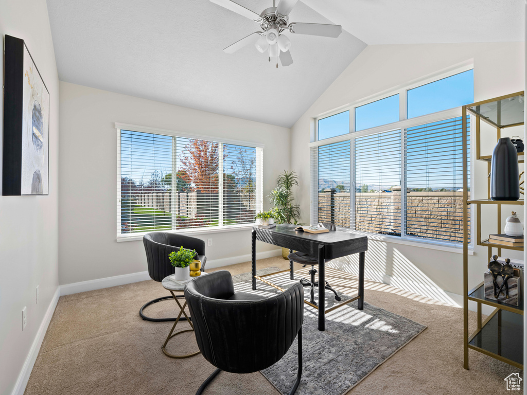 Carpeted home office featuring vaulted ceiling and ceiling fan