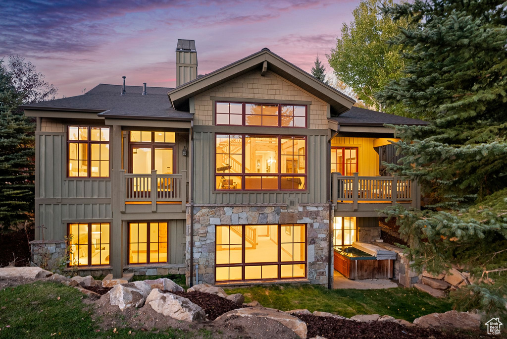 Back house at dusk with a balcony