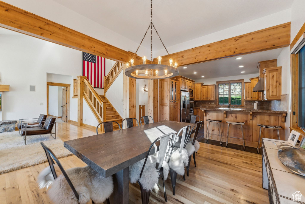 Dining room with sink, a chandelier, and light hardwood / wood-style flooring