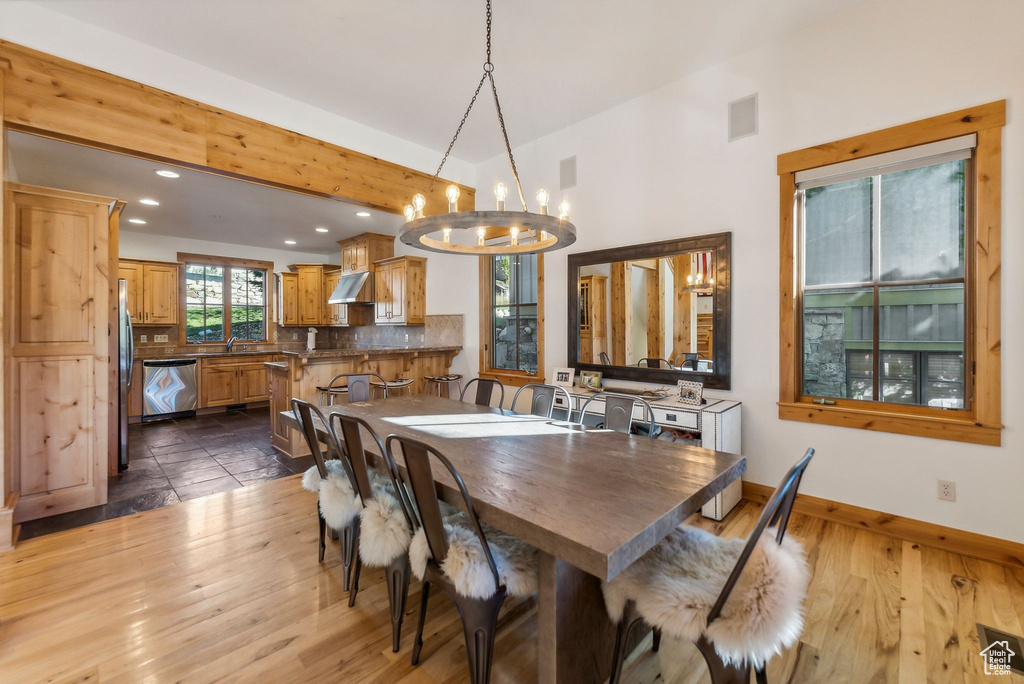 Dining room featuring dark wood-type flooring, sink, and a chandelier